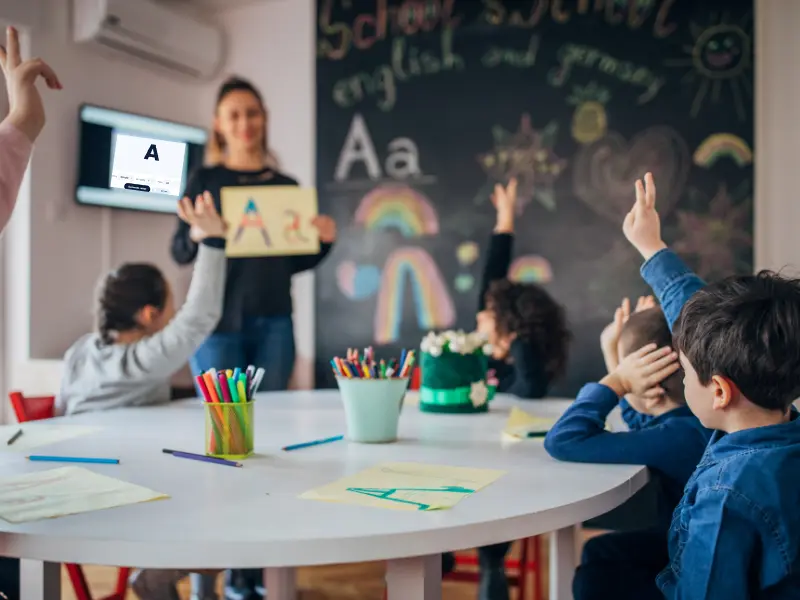 Teacher using random letter generator to teach phonics and alphabet recognition to children